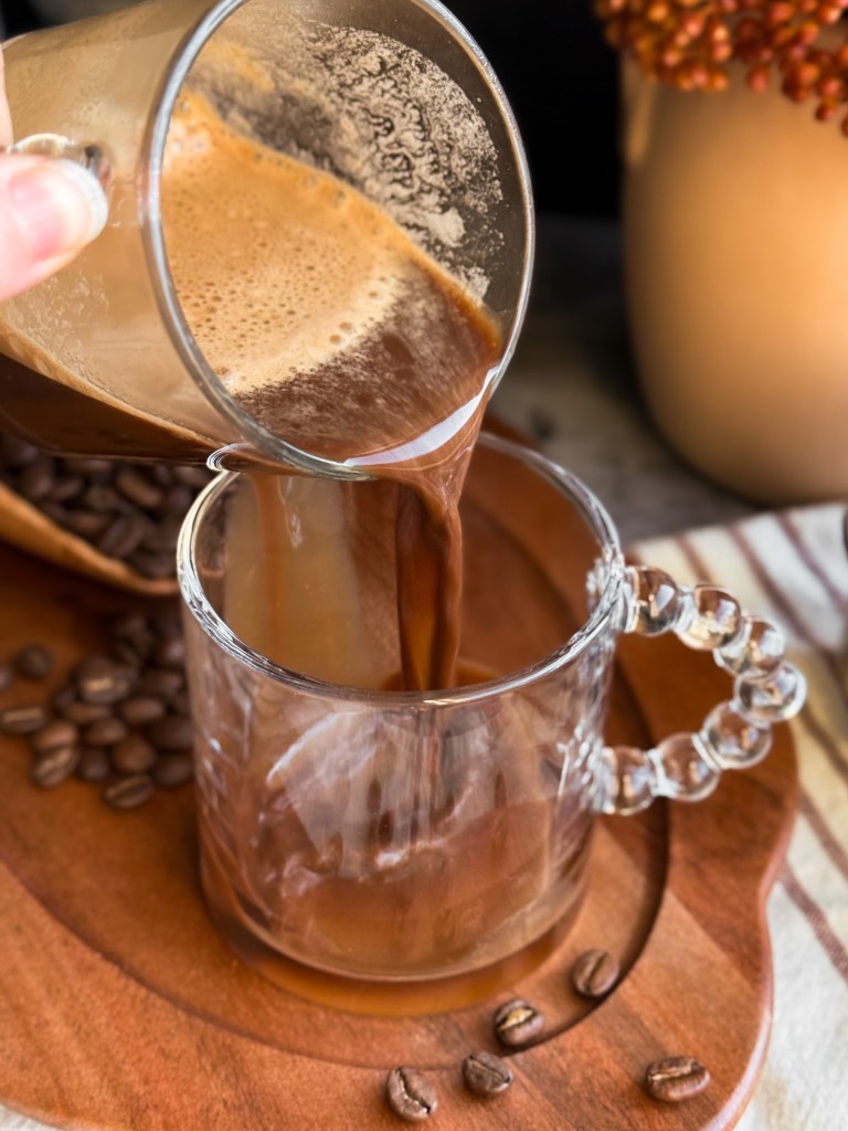 Pouring Healthy Hot Mocha Latte with Chocolate Date Syrup into a mug