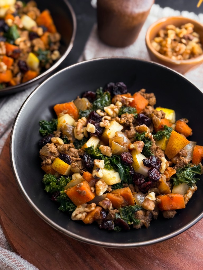 Side view of One-Pan Harvest Skillet that features sweet pear, tart cranberries (in dried craisin form), and crunchy walnuts. A recipe created by home-cooked living, a healthy recipe website.