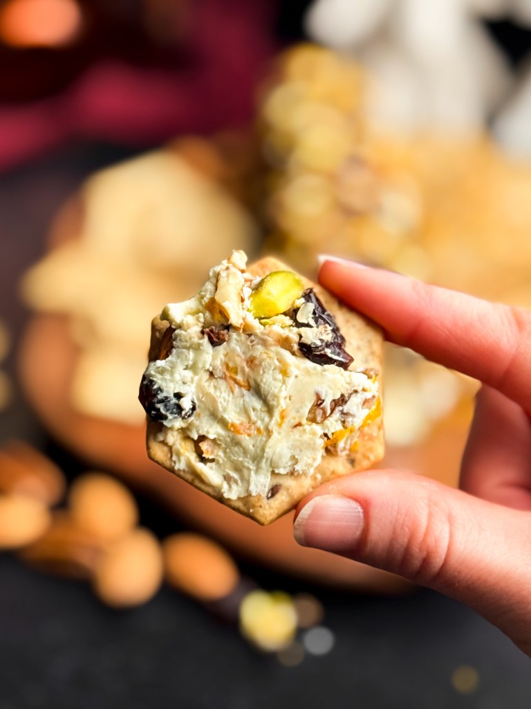 the BEST Christmas Cheese Log, smeared on a cracker.