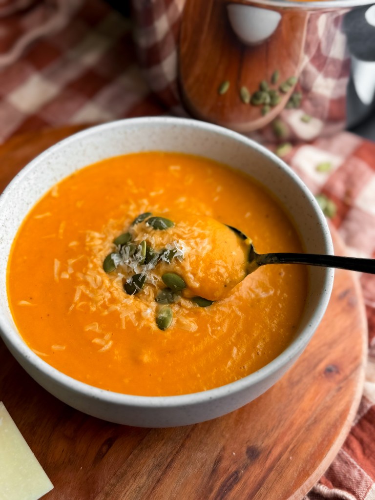 Dipping a spoon into Pumpkin Tomato Soup by home-cooked living