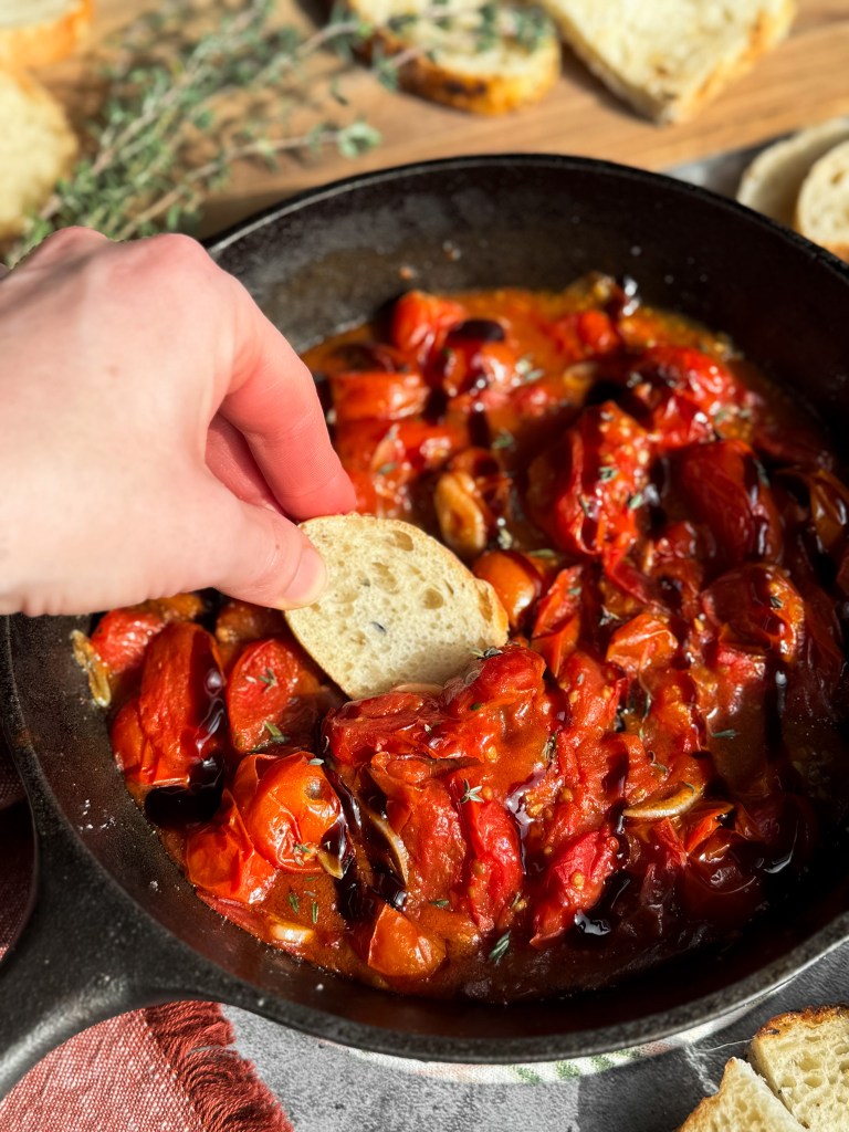 Blistered Tomatoes Appetizer in a cast iron skillet, garnish with fresh thyme (or basil) and a drizzle of balsamic glaze