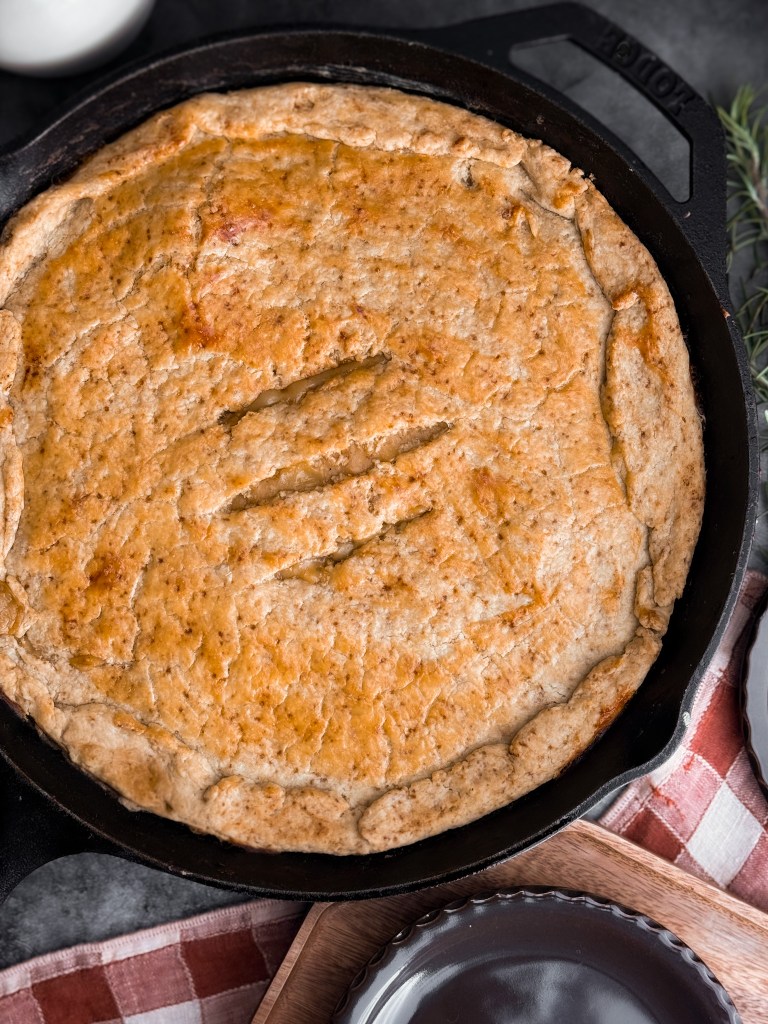 The Easiest Chicken Pot Pie in One-Pan - the filling is made in a cast iron skillet, topped with a homemade pie crust, then baked in the oven until golden.
