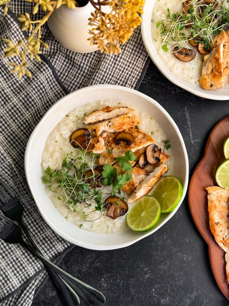 Brothy Coconut Lime Rice and Chicken bowl with fresh lime slices, microgreens, and sautéed mushrooms