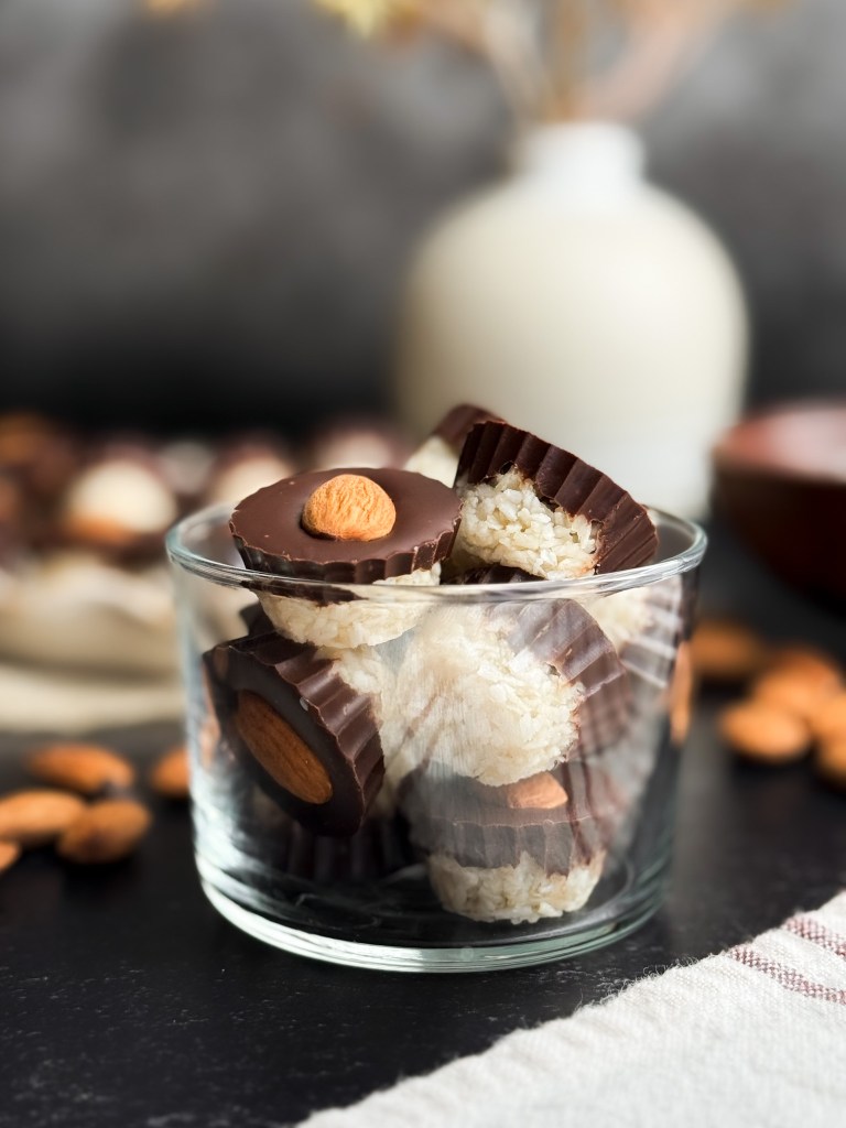 Healthy Almond Joy Cups piled high in a clear glass cup - healthy almond joys.